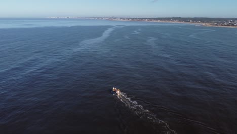 Stunning-aerial-4k-cinematic-high-angle-drone-footage-of-fishing-boat-navigating-in-blue-ocean-water-of-Uruguay