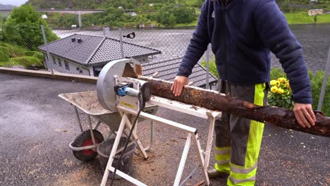 Male-european-using-electric-saw-to-cut-firewood-to-prepare-for-upcoming-winter-and-energy-shortage---Static-clip-with-no-face