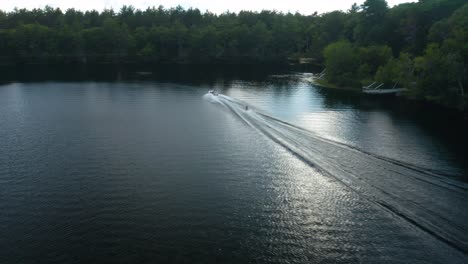 A-skier-being-towed-behind-a-powerboat-while-participating-in-the-fast-paced-activity-of-water-skiing,-which-involves-skimming-the-surface-of-the-water-with-one-or-more-skis