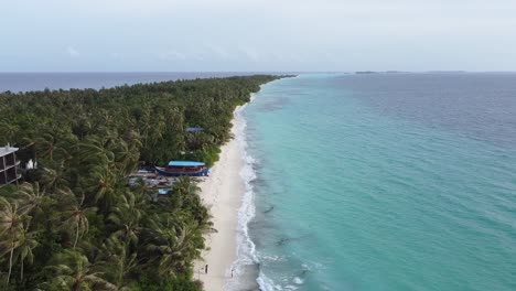 Hermoso-Resort-De-Vacaciones-De-Lujo-En-La-Isla-De-Dhigurah-Maldives-Con-Océano-Turquesa-Y-Palmeras,-Drone-Al-Revés