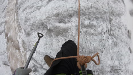 A-crystal-seeker-mountaineer-climbs-a-mountain-and-crosses-a-crevasse-in-a-glacier-in-the-swiss-alps-with-his-equipment,-pickaxe,-rope