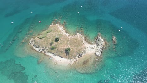 Luftaufnahmen-Einer-Kleinen-Insel-In-Kroatien-Mit-Einigen-Kleinen-Booten,-Die-Das-Türkisfarbene-Mittelmeer-Genießen