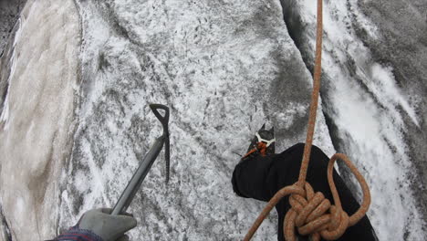 An-alpinist-is-walking-on-a-glacier-in-Switzerland-to-find-crystal-with-all-his-equipement,-rope