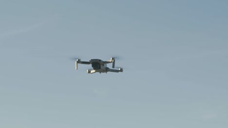 Eine-Kleine-Drohne-Fliegt-In-Zeitlupe-In-Den-Himmel-Und-Fängt-Die-Umgebende-Landschaft-Ein