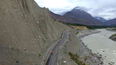 Filmación-Cinematográfica-De-Drones-Siguiendo-Un-Tuk-tuk-En-La-Autopista-Karakoram-Pakistán-A-Lo-Largo-Del-Río-Hunza