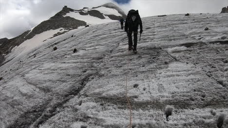 Un-Buscador-De-Cristal,-Alpinista-En-Los-Alpes-Suizos,-Camina-Por-Una-Montaña-En-Un-Glaciar-Con-Todo-Su-Equipo,-Casco