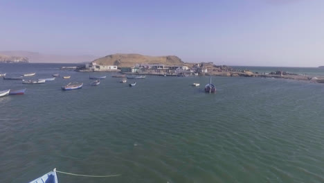 Zoom-in-with-drone-of-a-sea-full-of-fishing-boats-floating-during-the-day