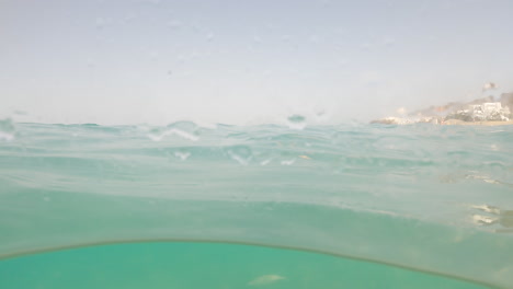 Ein-Blick-Durch-Das-Nasse-Kameraobjektiv-Von-Fischen,-Die-Unter-Der-Meeresoberfläche-In-Fuerteventura,-Spanien-Schwimmen