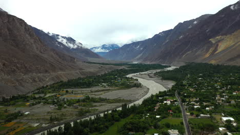 Cinematic-drone-shot-of-small-town-or-village-in-the-valley,-Passu-Cones-in-Hunza-Pakistan,-Hunza-River,-high-wide-aerial-shot