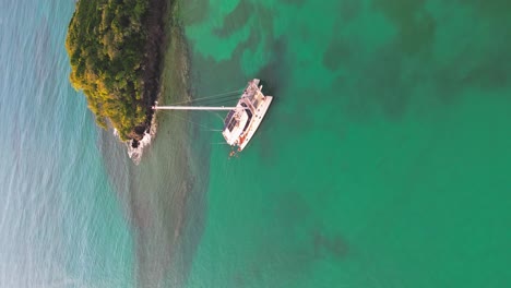 Vertical-Shot-Of-Catamaran-Yacht-Sailing-Near-Playa-Bonita-Island-In-Las-Terrenas,-Dominican-Republic