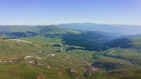 Aerial-view-of-village-among-green-meadows-and-mountains-in-summer-Georgia