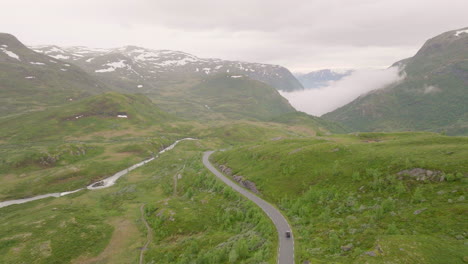 Car-drives-along-scenic-Sognefjellsvegen,-Norwegian-alpine-landscape