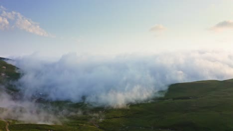 Dichter-Nebel-Und-Wolken,-Die-Bei-Sonnenuntergang-über-Das-Bergplateau-Kriechen