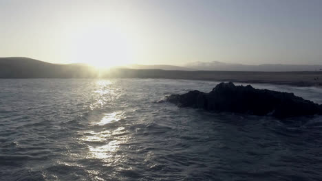 Erstaunliche-Drohnenaufnahme-Des-Meeres-Während-Des-Sonnenuntergangs,-Wenn-Die-Wellen-Gegen-Die-Felsen-Schlagen