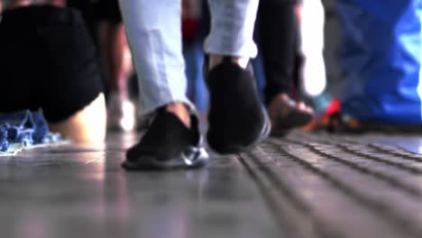 Crowd-of-people's-feet-wearing-casual-footwear-walking-in-slow-motion-indoors