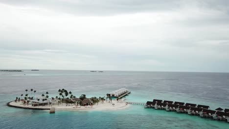 Drone-Vuela-Sobre-Una-Isla-Con-Villas-De-Agua-En-Un-Resort-De-Maldivas