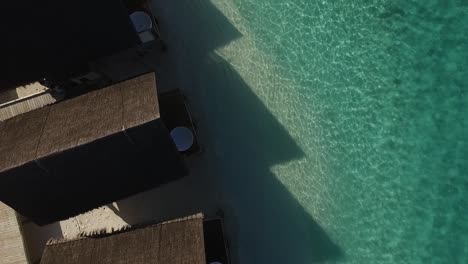 Drone-shot-above-water-villas-spa-roofs-in-a-Maldives-resort