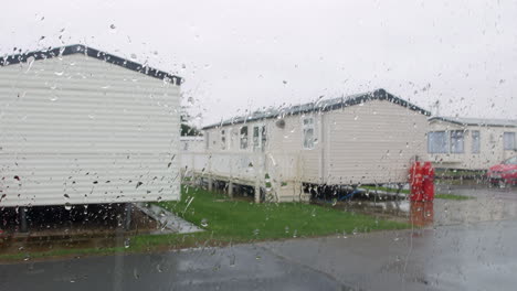 Rain-falling-on-a-caravan-trailer-vacation-camp-on-a-wet-raining-staycation-at-a-British-holiday-seaside-resort
