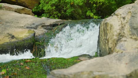 Beautiful-footage-of-a-fast-moving-stream-cutting-between-two-rocks-in-the-forest