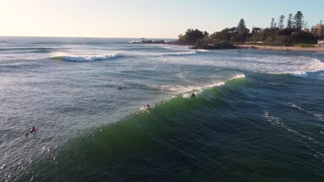 Aerial-drone-shot-of-main-town-beach-waves-foam-swell-surfer-riding-Pacific-Ocean-mid-north-coast-headland-NSW-Port-Macquarie-Australia-4K