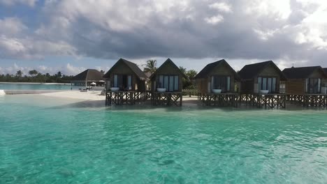 Drone-flies-towards-water-villas-spa-in-a-Maldives-resort