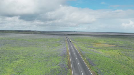 Cars-Driving-On-The-Ring-Road-Through-Fields-During-Summer-In-Iceland
