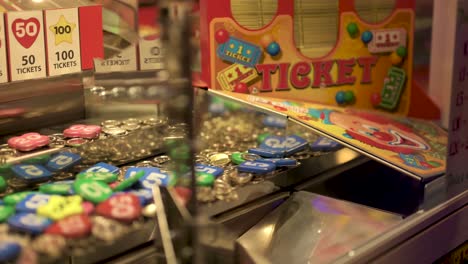 Arcade-coin-pusher-dropping-a-100-price,-slow-motion