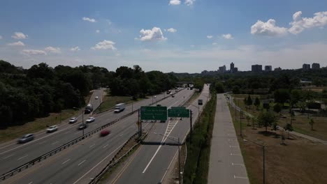 An-aerial-time-lapse-over-an-expressway-on-a-sunny-day-in-Queens,-NY