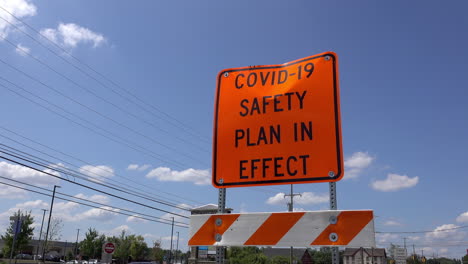 A-COVID-safety-sign-with-traffic-passing-by