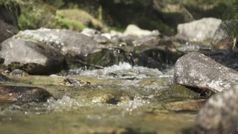 Slow-Motion-Of-Clear-Mountain-River-Flowing-Over-Rocks-In-Sunny-Day