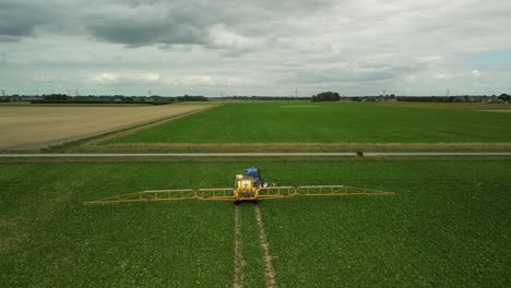 Flying-behind-a-tractor-with-trailed-sprayer-follows-the-tracks-in-a-field-and-turns-to-the-right