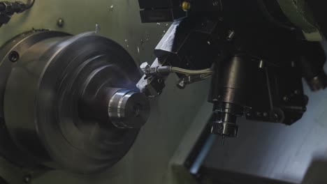 Industrial-Lathe-shaving-precision-edge-into-steel-pipe,-close-up
