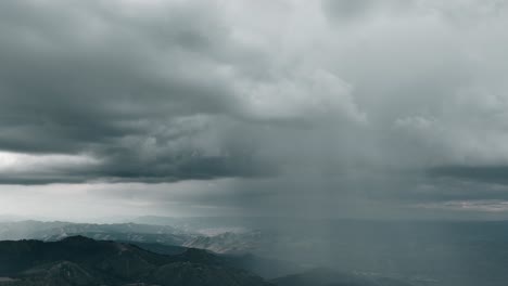 Aerial-of-storm-clouds-raining-down-on-mountain-range