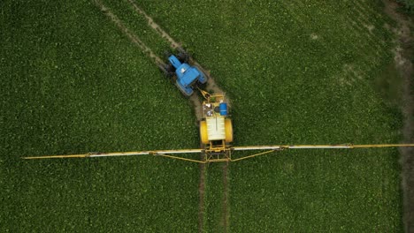Drone-footage-right-above-a-tractor-with-a-trailed-sprayer-turning-left-in-a-field
