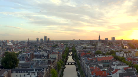 Slow-Drone-shot-over-central-Amsterdam-Canal-Zuiderkirk-at-sunrise
