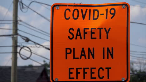 COVID-safety-sign-in-safety-orange-stands-roadside