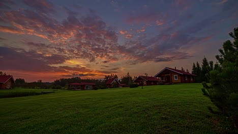 Timelapse-shot-of-beautiful-wooden-cottages-along-green-grasslands-during-evening-time