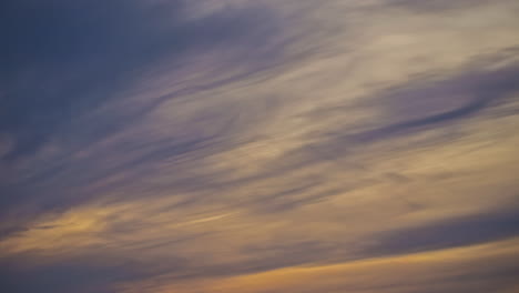 Low-angle-shot-of-Cirrostratus-clouds-passing-by-in-timelapse-during-evenign-time-after-sunset