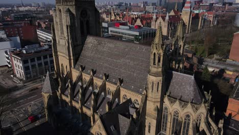 Aerial-drone-flight-around-the-Church-of-the-Holy-Name-of-Jesus-Christ-on-Oxford-Road-in-Manchester-showing-the-rooftops-and-its-Gothic-architecture