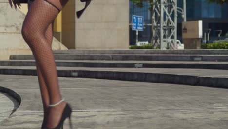 Young-woman-walks-in-high-heels-and-sexy-lingerie-outfit-outdoors-in-the-city