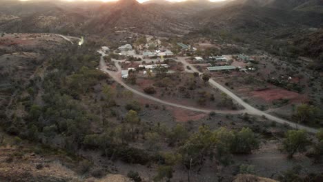 Absteigende-Luftaufnahme-Des-Kleinen-Dorfes-Arkaroola-Während-Des-Sonnenuntergangs-Mit-Berggipfelsilhouette