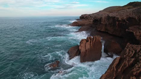 Panoramic-view-of-waves-breaking-hard-on-the-cantabrian-coast-with-natural-colors-in-Isla,-a-village-of-Cantabria,-Spain