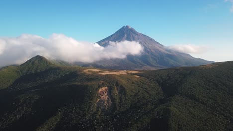 Langsamer-Rückwärtsclip-Des-Vulkanischen-Taranaki-Berges,-Der-Teilweise-Von-Dicken-Weißen-Wolken-Bedeckt-Ist