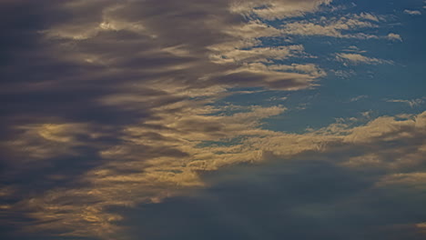Tiefwinkelaufnahme-Dunkler-Wolkenbewegungen-Entlang-Des-Blauen-Himmels-Im-Zeitraffer-Während-Der-Abendzeit
