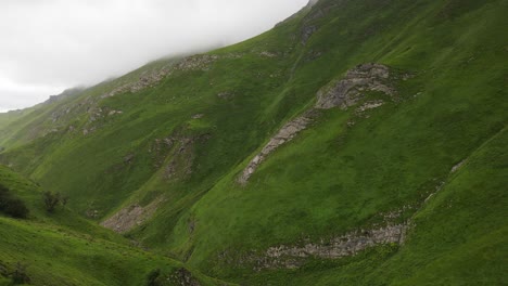 Ein-Frisches-Grünes-Bergtal-Mit-Kühlen-Wolken,-Die-Sich-Auf-Dem-Gipfel-Bilden