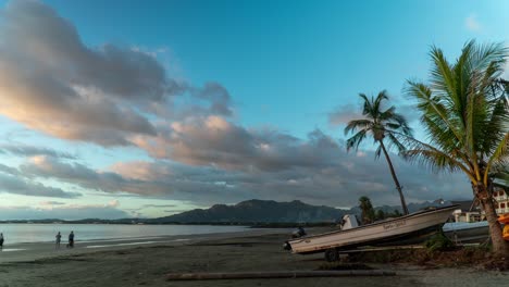 Golden-hour-sunset-on-tropical-beach-mainland-Fiji,-boat-on-shore,-timelapse