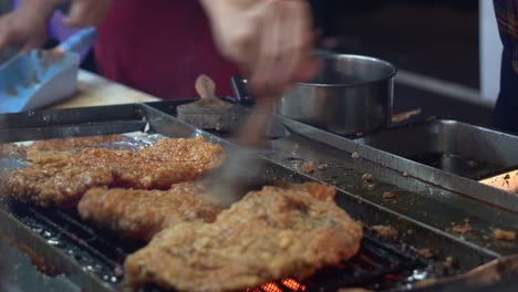 Mouthwatering-delicious-honey-soy-coated-fried-chicken-fillet-grilling-on-hot-grill,-professional-chef-brush-tasty-sauce-on-the-meat-with-aromatic-smell-at-famous-night-market,-Taiwan,-Asia