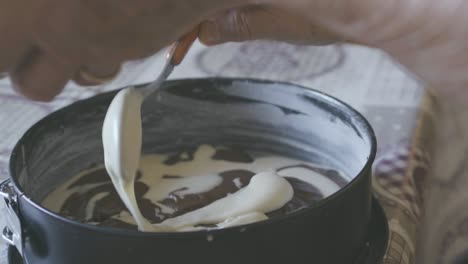 A-lady-puts-cake-batter-in-the-pan,-detail-and-slow-motion