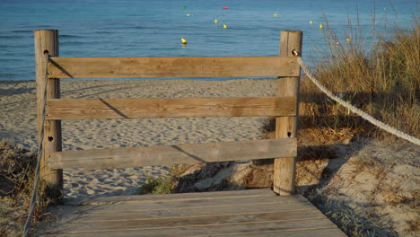 Wooden-barrier-blocking-access-to-a-golden-sandy-beach-for-sanitary-reasons