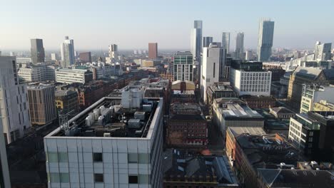 Aerial-drone-flight-passing-low-over-the-rooftops-in-Piccadilly-Gardens-and-Chinatown-in-Manchester-City-Centre-with-a-skyline-view-of-the-South-Towers